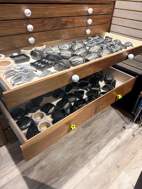 Walnut fitting drawers stocked with interchangeable driver and fairway heads
